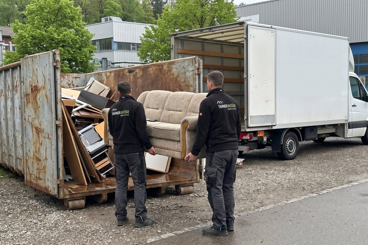 Ein altes Sofa wird in die Mulde gehoben