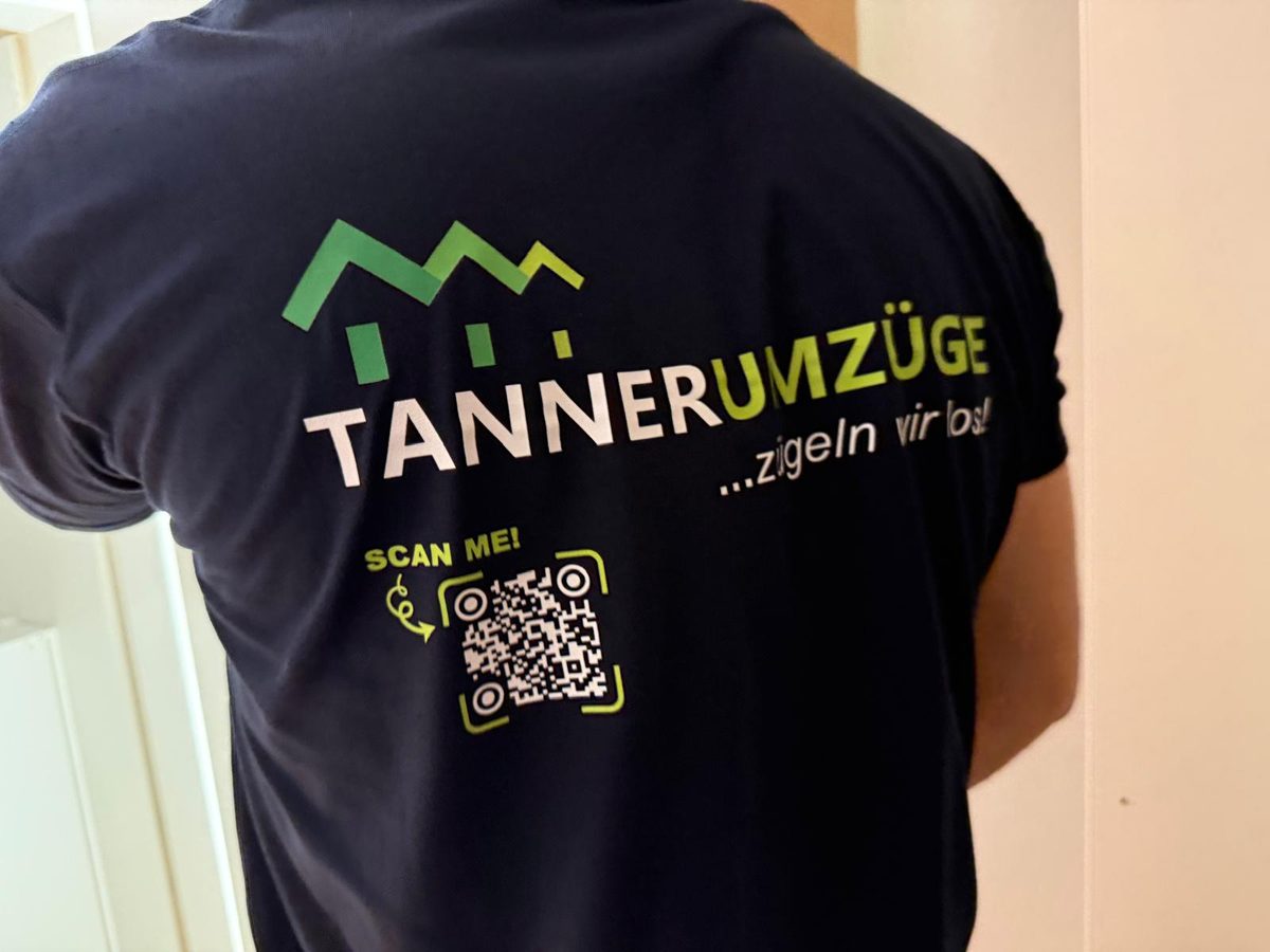 Rücken eines dunkelblauen T-Shirts von Tanner Umzüge mit Logo, dem Satz «…zügeln wir los!» und einem QR-Code